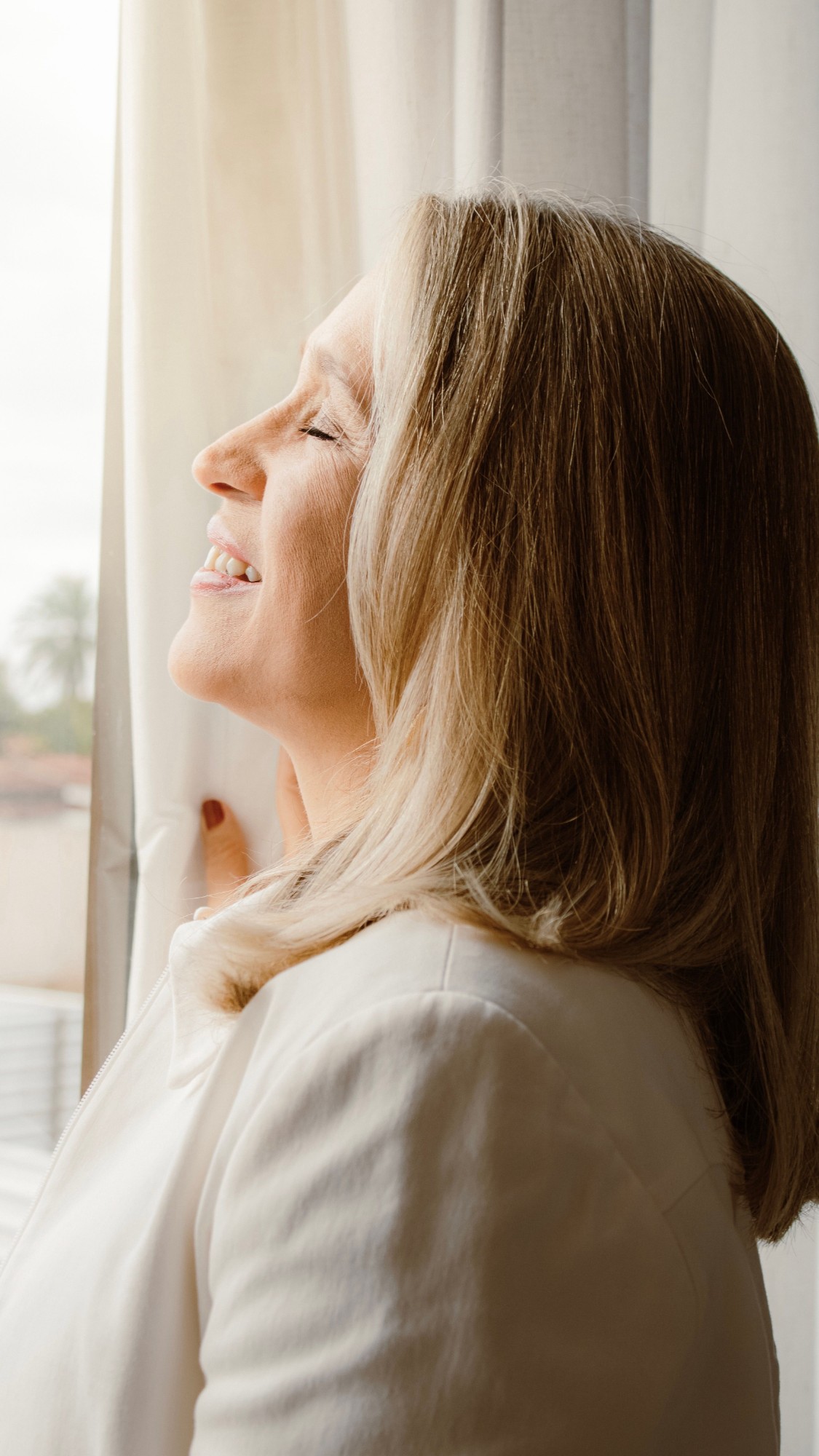 Woman smiling peacefully relieved after a successful move into her new home