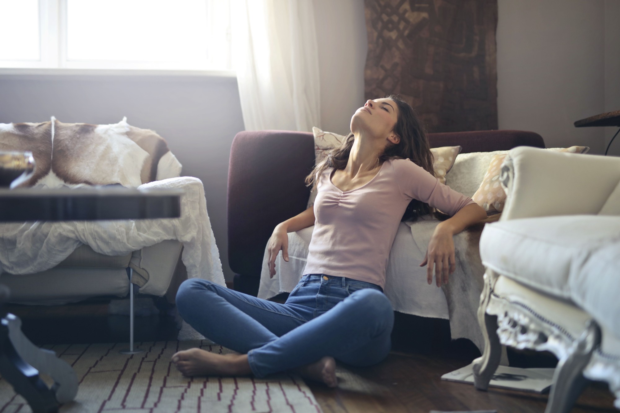 Woman exhausted and overwhelmed lying on floor surrounded by moving boxes
